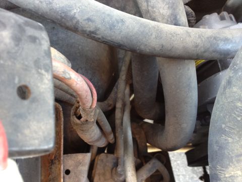1988 Ford Bronco - Close-up view of engine hoses and wiring, with some wear visible on the insulation of a red wire.