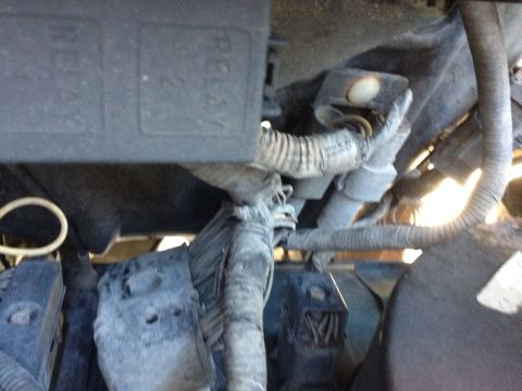 1988 Ford Bronco - This image shows a close-up view of the engine bay of a 1988 Ford Bronco, focusing on the electrical components and wiring harnesses. A bla…