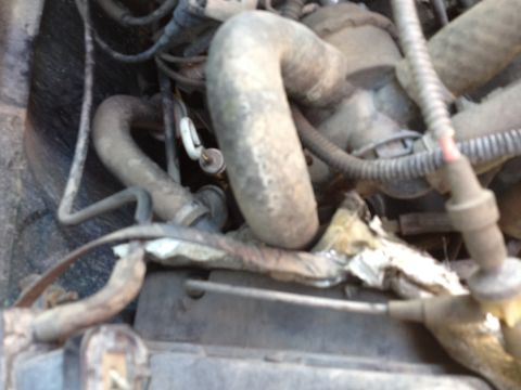 1988 Ford Bronco - A close-up view of engine components, including hoses and wiring, in a vehicle.