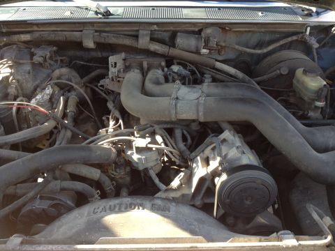 1988 Ford Bronco - A close-up view of the engine bay of a Ford Bronco, showing the air intake system, engine components, and the fan shroud with visible text.…