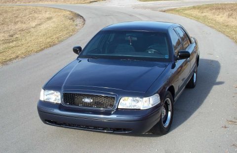 1998 Ford Crown Victoria - Dark blue 1998 Ford Crown Victoria parked on a winding road.