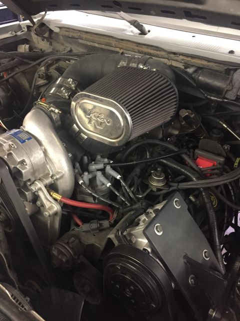 1988 Ford Bronco - The engine bay of a vehicle features a supercharger, a K&N air filter, and various hoses and wiring.