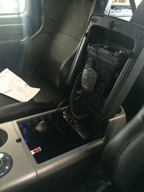 1988 Ford Bronco - The interior of a vehicle shows a center console with two radios installed. One radio is mounted in the open compartment of the console, an…