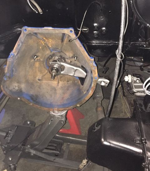 1978 Ford Bronco - A vehicle's transmission bell housing is shown removed and supported by a jack and jack stands. A clutch fork and throw-out bearing are vis…