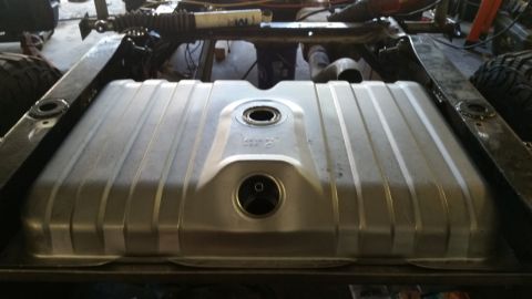 1979 Ford Bronco - A silver aftermarket fuel tank is installed under the chassis of a vehicle, likely a truck or SUV. The tank has a ribbed design and two cir…