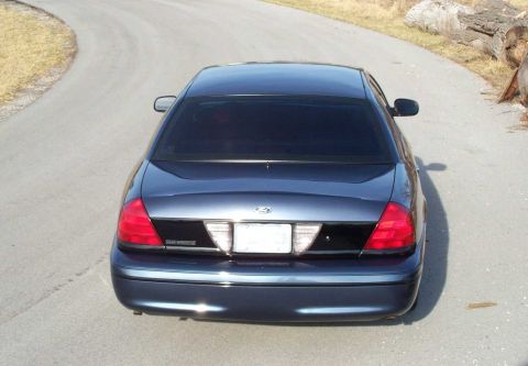 1998 Ford Crown Victoria - Rear view of a dark blue 1998 Ford Crown Victoria, showing its taillights and license plate area.