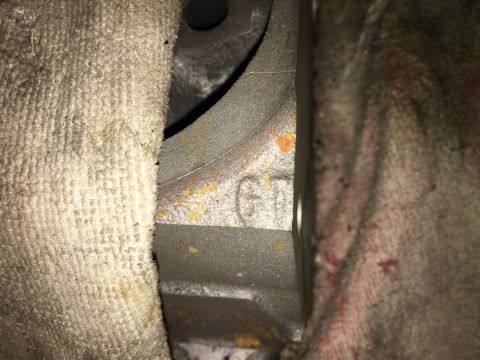 1993 Ford Bronco - A close-up view shows cast iron lettering "GH" on a vehicle engine block, partially obscured by dirty rags.