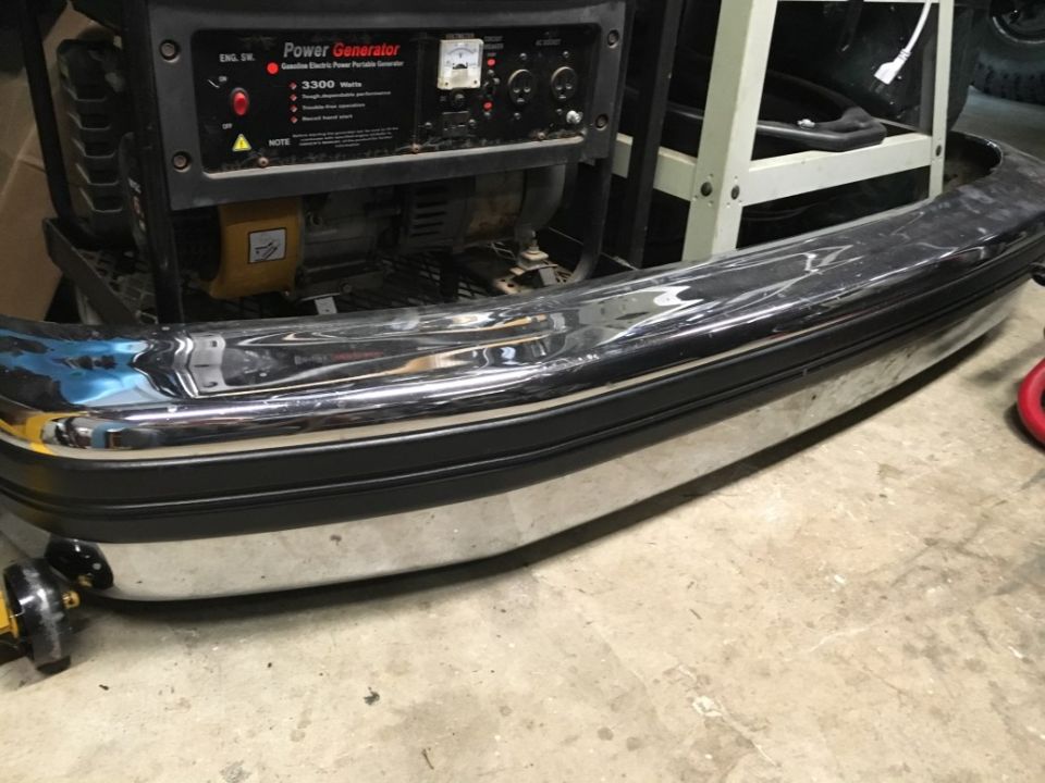 Chrome and black bumper with a generator behind it.
