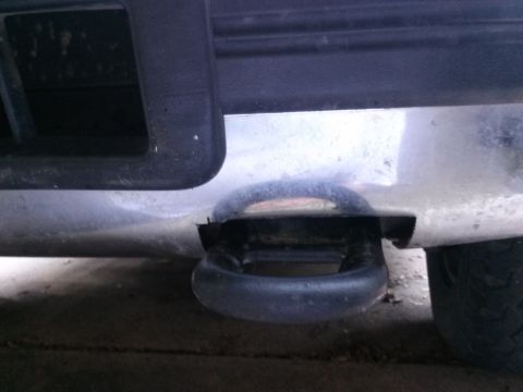 1996 Ford Bronco - A close-up view of a black tow hook integrated into the front bumper of a vehicle. The tow hook is U-shaped and appears to be made of heavy…