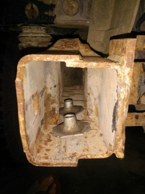 1996 Ford Bronco - The interior of a heavily rusted, square metal channel, likely part of a vehicle frame or bumper mount, shows two silver metal brackets wit…