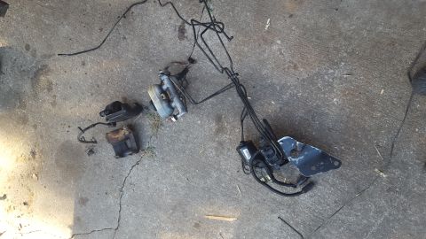 1994 Ford Bronco - A collection of brake system components, including a master cylinder, brake booster, and hydraulic lines, are laid out on a concrete surfac…