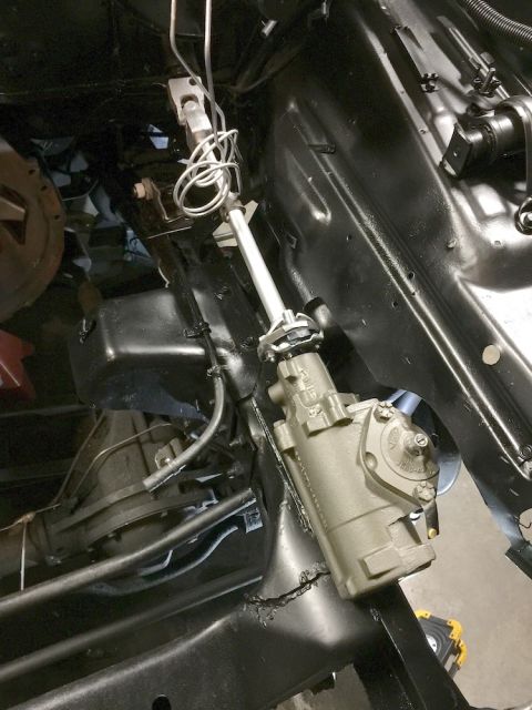 1978 Ford Bronco - A close-up view shows a rebuilt steering gearbox assembly mounted to the frame of a classic vehicle. The steering shaft extends upwards, co…