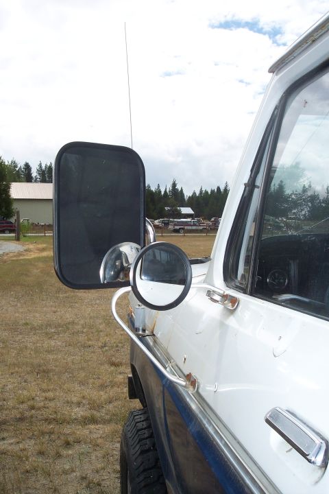1973 Ford F-250 - The side view of a white Ford F-250 pickup truck shows its large side mirror assembly and a smaller convex mirror attached to a chrome brac…