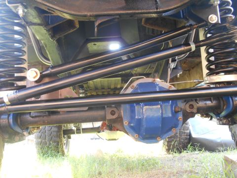 1972 Ford Bronco - The underside of a vehicle shows a blue differential housing, suspension components including springs and shock absorbers, and steering lin…