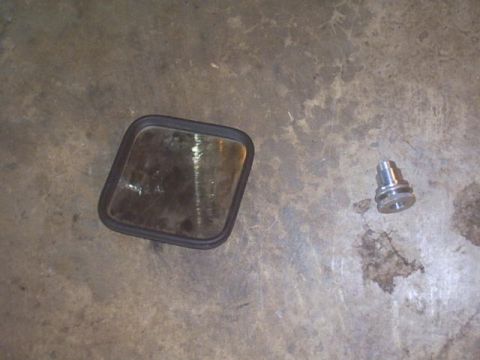 1991 Ford Crown Victoria - Side mirror glass and a metal fitting are shown on a concrete surface.
