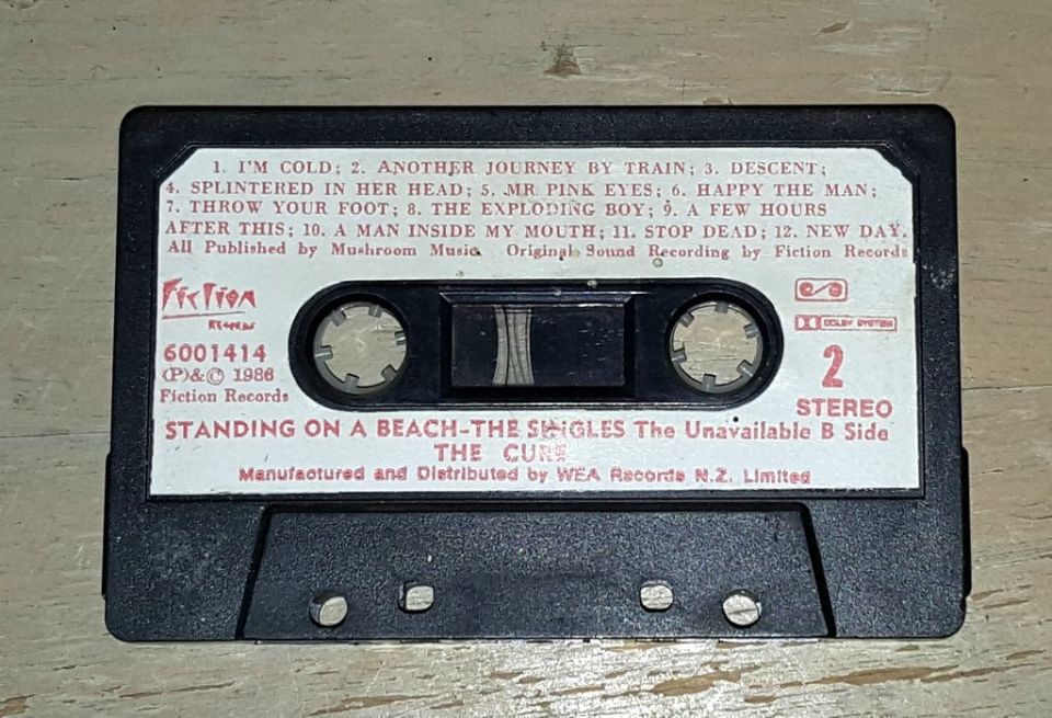 Cassette tape labeled 'STANDING ON A BEACH-THE SINGLES The Unavailable B Side THE CURE'