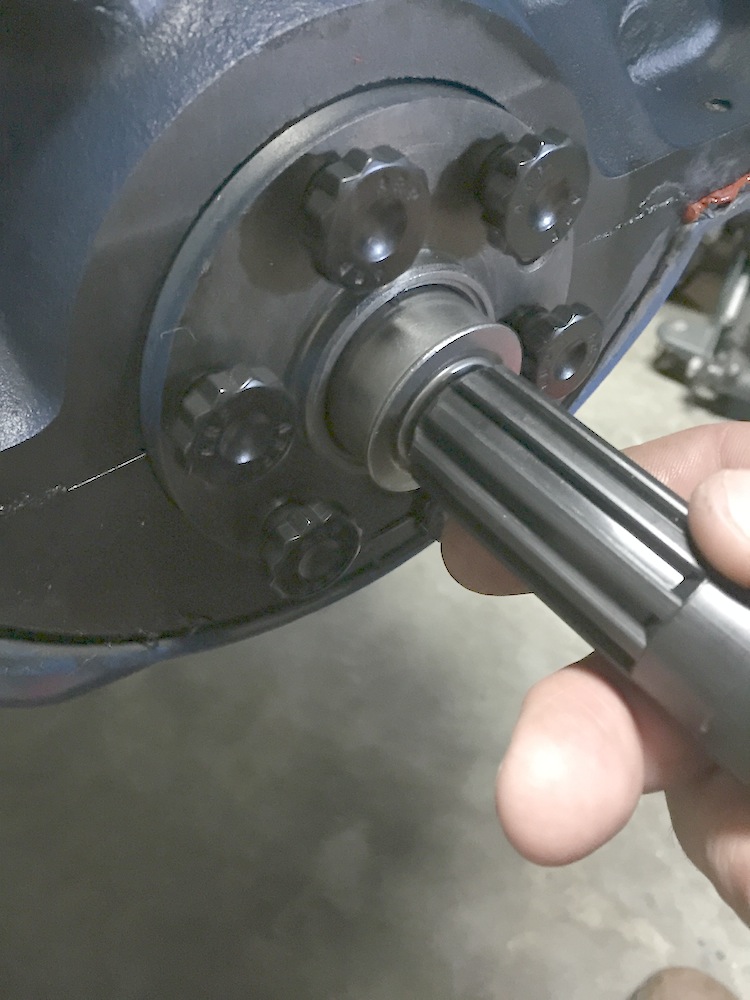 hand holding splined shaft near a bolted housing
