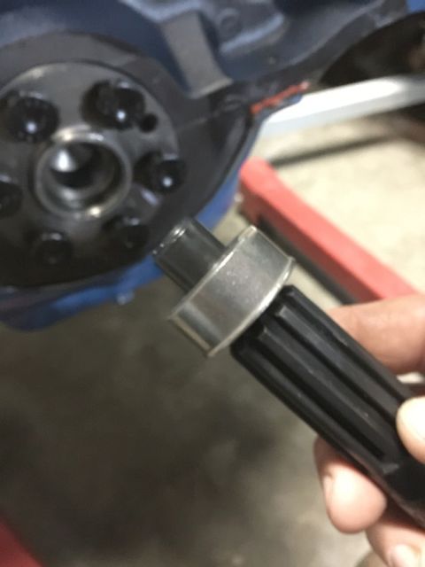1978 Ford Bronco - A hand holds a splined shaft with a metal ring, part of a vehicle's mechanical system.