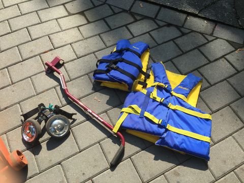 1979 Ford Bronco - Life vests and a boat trailer dolly are laid out on a paver patio.
