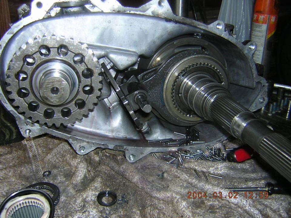 Open transfer case with drive chain, sprocket, and splined output shaft during rebuild
