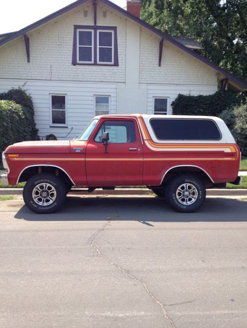 1978 Ford Bronco - This 1978 Ford Bronco features a distinctive red paint job with a white hardtop and colorful side stripes.