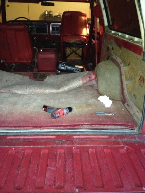 1978 Ford Bronco - Tools are laid out in the cargo area of a red SUV, suggesting ongoing maintenance or repair work.