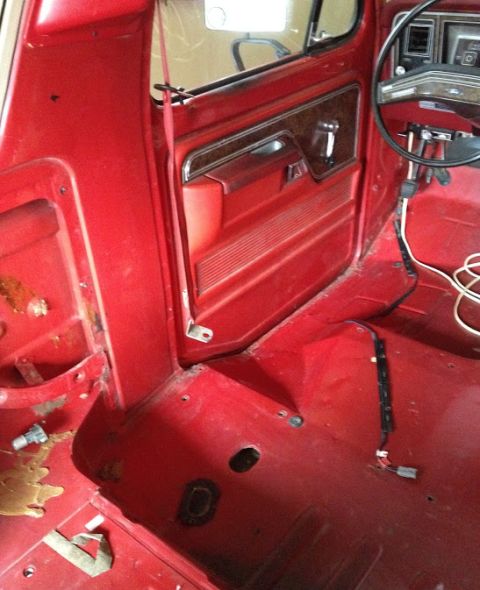 1978 Ford Bronco - Interior view of a 1978 Ford Bronco, highlighting the red door panel and dashboard details.