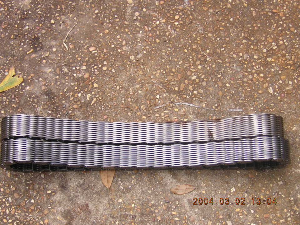 Metal segmented drive belt lying on concrete ground