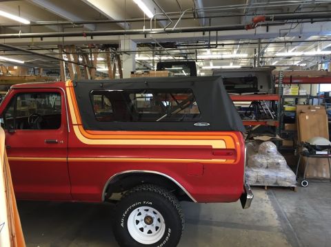 1978 Ford Bronco - This 1978 Ford Bronco features a distinctive stripe package and a black soft top, seen in an indoor storage area.