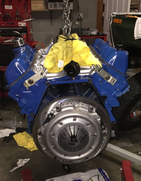 1978 Ford Bronco - Engine and clutch assembly suspended by a chain hoist, ready for installation or removal.