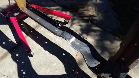 1994 Ford Bronco - A vehicle frame section is supported by a red engine stand on a concrete surface.