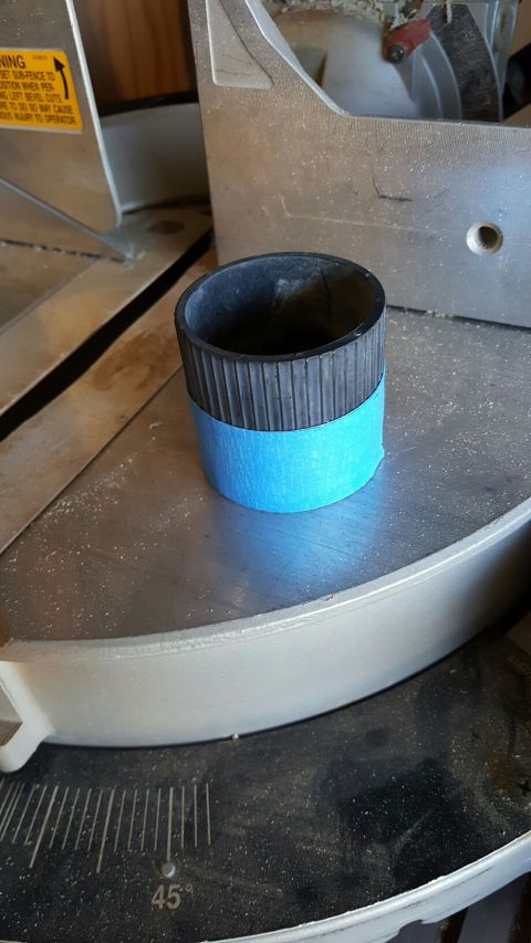 1996 Ford Bronco - A black rubber part, marked with blue tape, sits on a miter saw table.