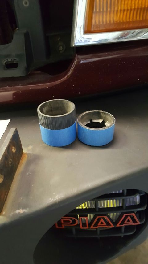 1996 Ford Bronco - Two metal cylinders with blue tape sit on a surface near a vehicle grille.