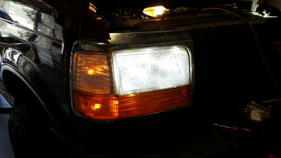 Black Ford Bronco front headlight assembly with amber turn signal and chrome trim