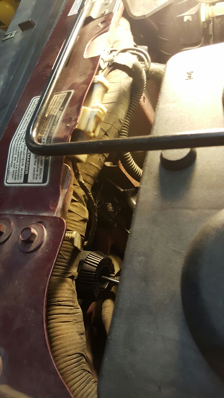 Engine bay wiring harness with a black circular component