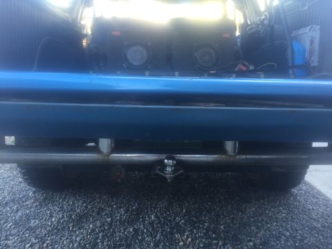 1979 Ford Bronco - Rear view of a blue vehicle showing a trailer hitch and aftermarket speakers in the cargo area.