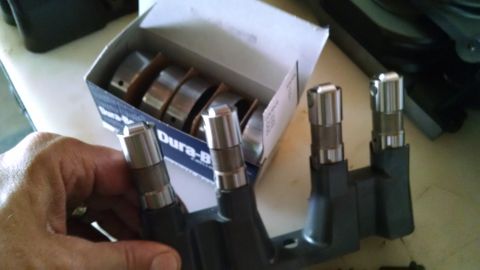 1985 Jeep CJ7 - A hand holds engine lifters next to a box of Dura-Bilt bearings.