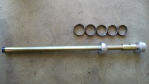 1985 Jeep CJ7 - A metal rod with five rings is laid out on a concrete surface.