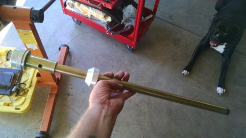 1985 Jeep CJ7 - Close-up of a steering column part being held, with a tool cart and dog nearby.
