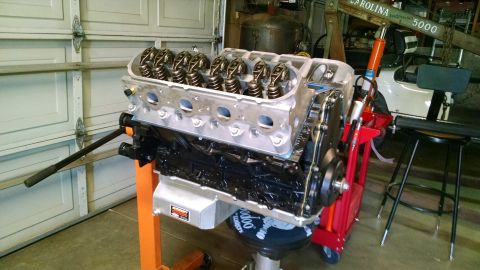1985 Jeep CJ7 - Engine assembly with exposed valve train components sits on a stand in a workshop environment.