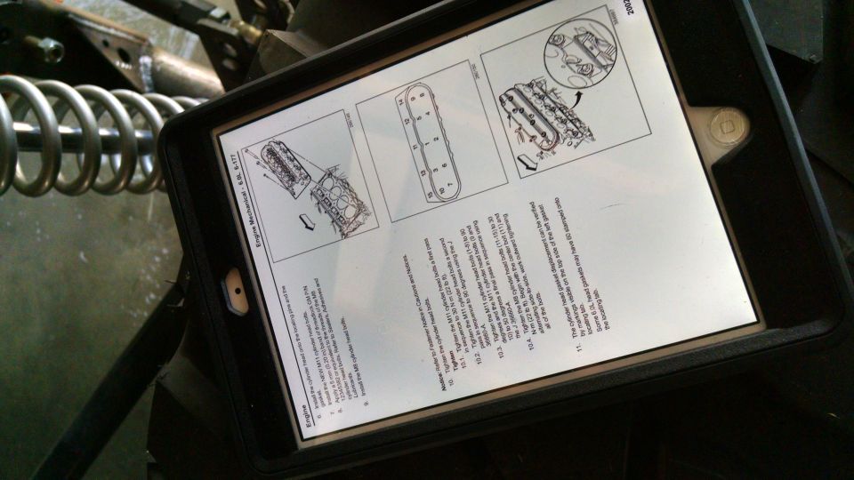 Tablet displaying engine repair manual with diagrams and text