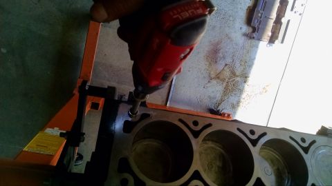 1985 Jeep CJ7 - Impact driver is used to work on an engine block. Engine block has cylinder cutouts.