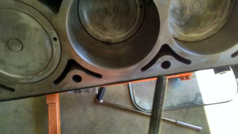 1985 Jeep CJ7 - The inside of an engine block with three visible cylinders, resting on an orange engine stand.