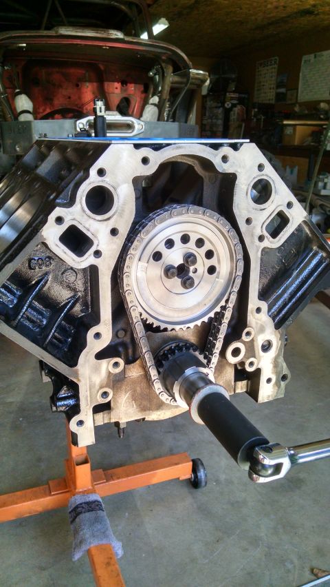 1985 Jeep CJ7 - Close-up view of an engine block's timing chain and gears, mounted on an orange engine stand.