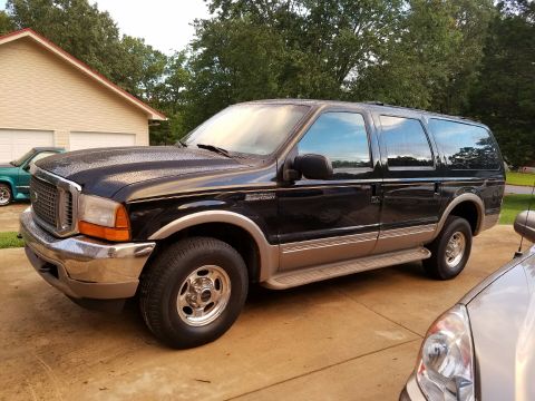 2001 Ford Excursion - A black Ford Excursion with tan trim is parked in a driveway.