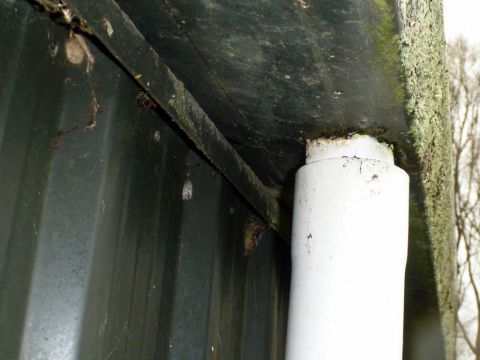1969 Lincoln Continental - Close-up view of the underside of a vehicle, showing a white pipe and corroded metal.