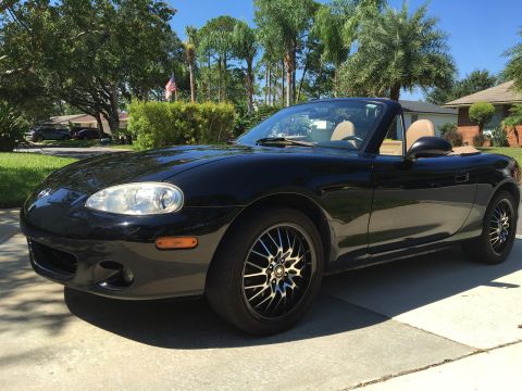 2001 Mazda Miata - This black 2001 Mazda Miata convertible is shown from the front three-quarter view.