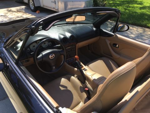2001 Mazda Miata - Interior of a black 2001 Mazda Miata convertible with tan leather seats and dashboard.
