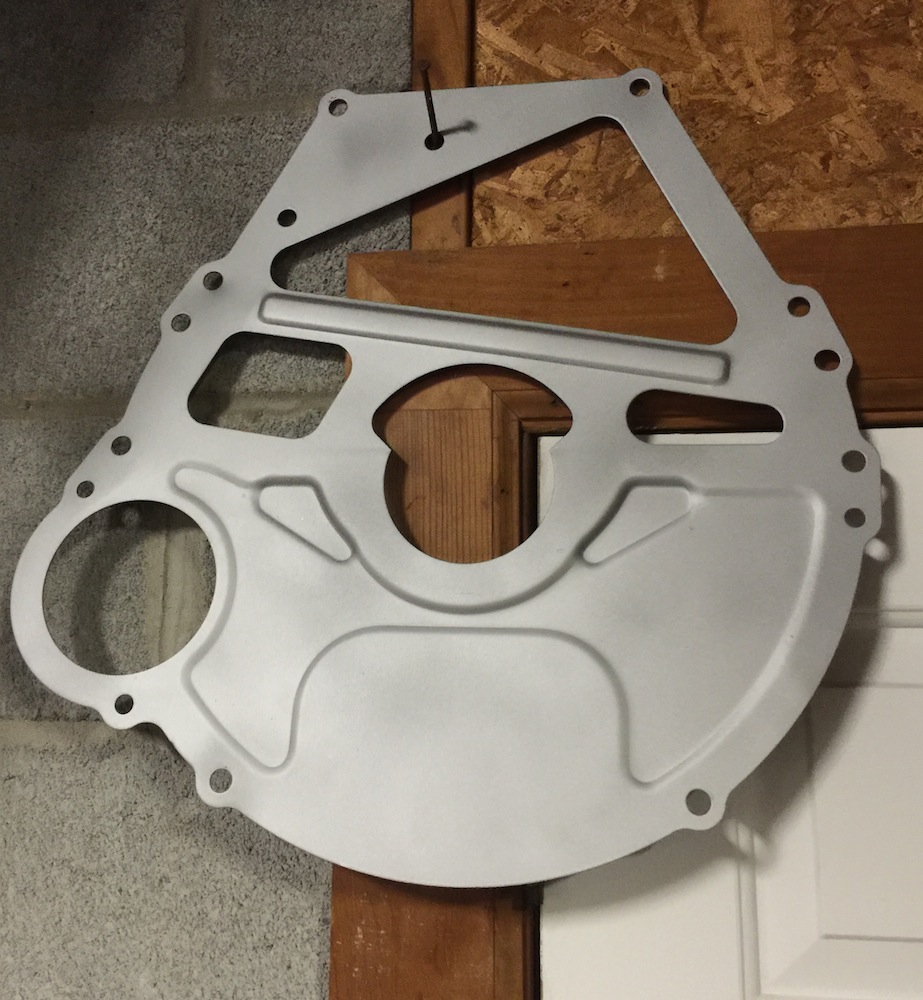 metal adapter plate for transmission, hanging on a wall