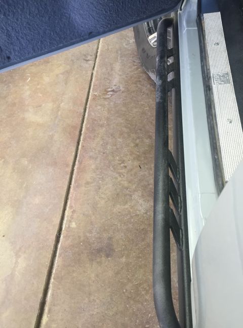 1988 Ford Bronco - Close-up view of aftermarket rock sliders installed on a vehicle's side.